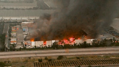 This photo taken from video provided by KABC-TV shows a raging fire destroying a huge commercial building Friday, June 5, 2020, in Redlands, Calif., about 60 miles (96 kilometers) east of Los Angeles. Firefighters from a half-dozen area agencies aided the Redlands Fire Department in shooting streams of water on flames that engulfed the structure, collapsed the roof and burned truck trailers parked at loading docks. The nearby 10 Freeway was shut down in both directions for several hours as flames shot high into the air.