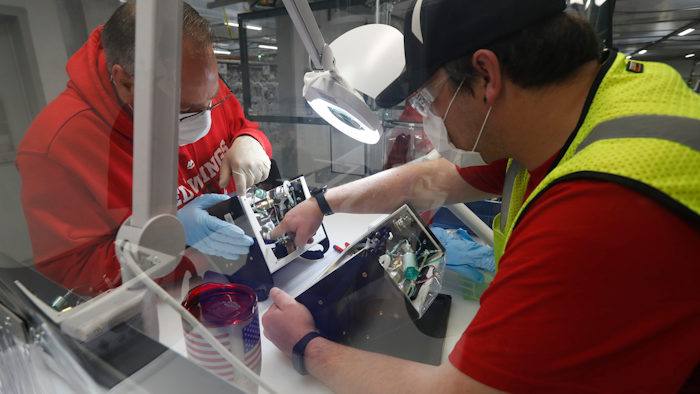 In this May 13 photo, Ford Motor Co. employees work a ventilator at the Rawsonville plant in Ypsilanti Township, Mich. The plant was converted into a ventilator factory, as hospitals battling the coronavirus report shortages of the life-saving devices.
