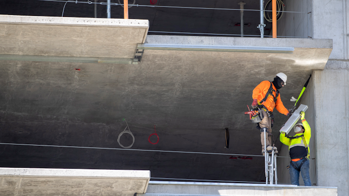 In this May 20 photo, a construction worker stands on stilts while working at a residential building construction site at the Harbor Point redevelopment site on the Stamford, CT waterfront.