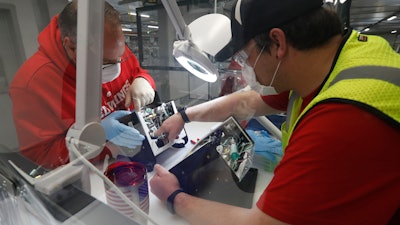 In this May 13 photo, Ford Motor Co. employees work a ventilator at the Rawsonville plant in Ypsilanti Township, Mich. The plant was converted into a ventilator factory, as hospitals battling the coronavirus report shortages of the life-saving devices.