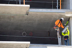 In this May 20 photo, a construction worker stands on stilts while working at a residential building construction site at the Harbor Point redevelopment site on the Stamford, CT waterfront.