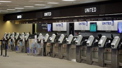 In this April 24 file photo, empty United Airlines ticket machines are shown at the Tampa International Airport in Tampa, FL. United United Airlines will send layoff warnings to 36,000 employees - nearly half its U.S. staff - in the clearest signal yet of how deeply the virus outbreak is hurting the airline industry.