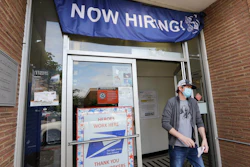 In this June 4 photo, a customer walks out of a US Post Office branch and under a banner advertising a job opening, in Seattle. Unemployment remains painfully high in the US even as economic activity is slowly picking up.