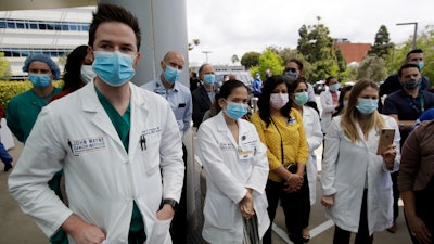 Hospital personnel stand outside Providence St. John's Medical Center in Santa Monica, Calif.