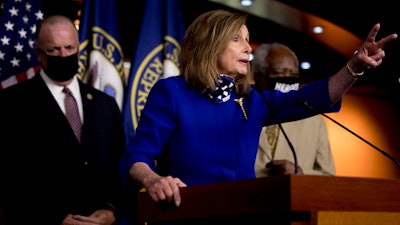House Speaker Nancy Pelosi of Calif., accompanied by Rep. Dan Kildee, D-Mich., left, and Rep. Danny Davis, D-Ill., right, speaks at a news conference on Capitol Hill in Washington on Friday, July 24, on the extension of federal unemployment benefits.