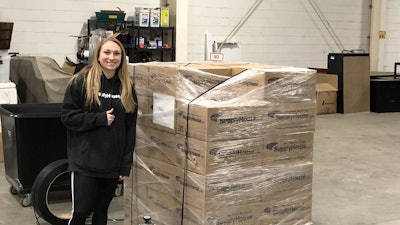 Corinne Cirabisi, HR representative, with packages of non-perishable food items and paper goods to be shipped to each of SupplyHouse.com's distribution centers for their warehouse team.