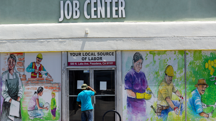 In this May 7, 2020 file photo, a person looks inside the closed doors of the Pasadena Community Job Center in Pasadena, CA during the coronavirus outbreak.