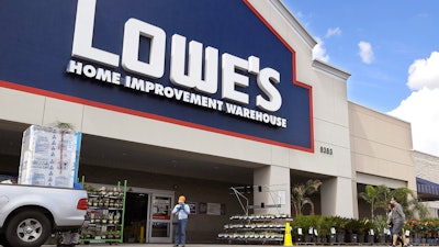 In this March 22 file photo, customers wearing masks walk into a Lowe's home improvement store in the Canoga Park section of Los Angeles.