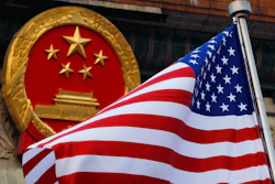 In this Nov. 9, 2017, file photo, an American flag is flown next to the Chinese national emblem during a welcome ceremony for visiting U.S. President Donald Trump outside the Great Hall of the People in Beijing. U.S. and Chinese trade envoys discussed strengthening coordination of their government’s economic policies during a phone meeting, the Ministry of Commerce announced.