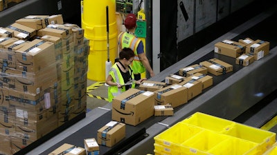 In this Feb. 9, 2018, file photo packages move down a conveyor system were they are directed to the proper shipping area at the new Amazon Fulfillment Center in Sacramento, Calif. Amazon said Monday, Sept. 14, 2020, that it will be hiring another 100,000 people to keep up with a surge of online orders. The company said the new hires will help pack, ship or sort orders, working in part-time and full-time roles. Amazon said the jobs are not related to its typical holiday hiring.