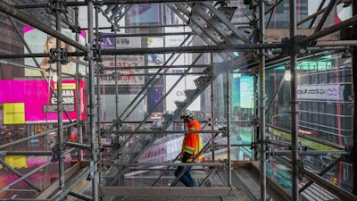 A construction worker walks down a staircase in the scaffolding of TSX Broadway under construction on Oct. 29 in New York's Times Square.
