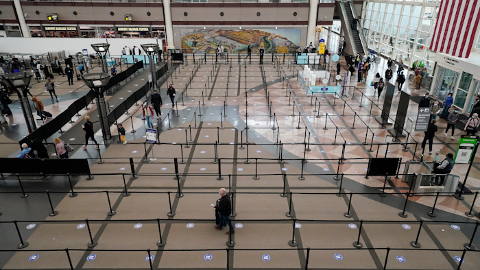 Travelers head through the south security checkpoint check in the terminal of Denver International Airport on Dec. 10 in Denver.