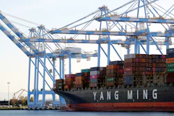 Cargo cranes take containers off a Yang Ming Marine Transport Corporation boat at the Port of Tacoma in Tacoma, Wash., Nov. 4, 2019.