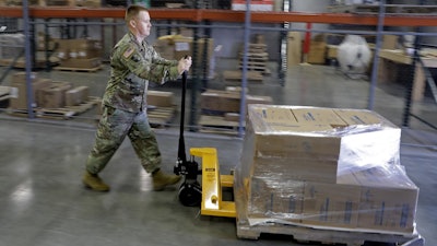 In this March 26 file photo, an Indiana National Guardsman pushes a pallet of medical supplies to be delivered in Indianapolis.