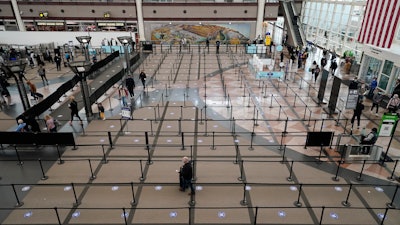 Travelers head through the south security checkpoint check in the terminal of Denver International Airport on Dec. 10 in Denver.