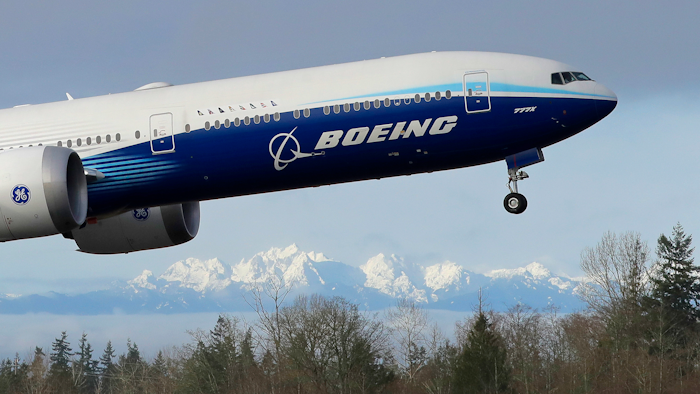 In this file photo a Boeing 777X airplane takes off on its first flight. Boeing is reporting another huge loss, this one because of a setback to its 777X widebody jetliner.