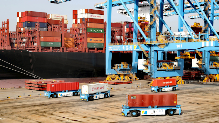 Automated vehicles move shipping containers in a container port in Qingdao in eastern China's Shandong Province. The U.S.-Chinese trade war isn't going away under President Joe Biden.