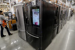 In this Jan. 27, 2020 file photo, a worker pushes a cart past refrigerators at a Home Depot store location in Boston.