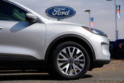 In this Oct. 11, 2020 file photo, a row of 2020 Ford Escape sports-utility vehicles sits at a Ford dealership in Denver.