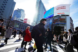 People wearing protective masks to help curb the spread of the coronavirus walk along pedestrian crossings Monday, Jan. 25, 2021 in Tokyo. The Japanese capital confirmed more than 600 new coronavirus cases on Monday.