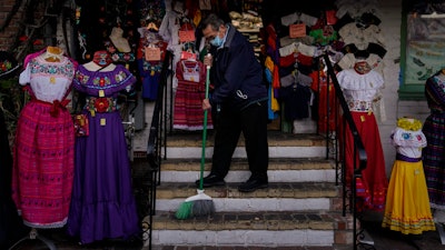 Victor Flores, 66, a third-generation owner of a gift shop, sweeps the steps of his store on Olvera Street in downtown Los Angeles. Millions of business owners are about to get additional help as they weather the coronavirus outbreak.