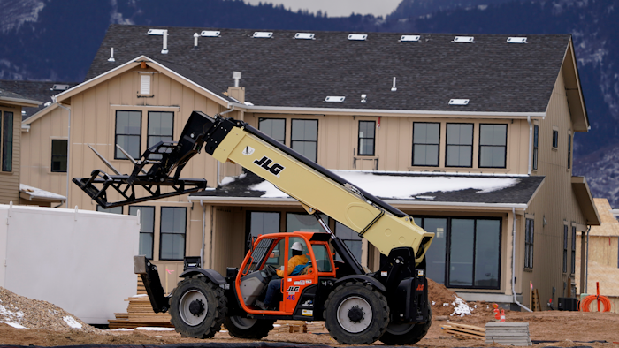 In this Dec. 1, 2020 file photo, workers toil on new homes under construction in a development near Chatfield State Park in Littleton, CO.