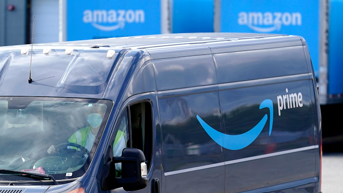 In this file photo, an Amazon Prime logo appears on the side of a delivery van as it departs an Amazon Warehouse location in Dedham, Mass.