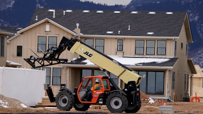 In this Dec. 1, 2020 file photo, workers toil on new homes under construction in a development near Chatfield State Park in Littleton, CO.