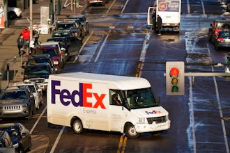 In this Dec. 29, 2020 photo, a FedEx delivery vehicle makes a U-turn near the Denver Pavilions, in downtown Denver.