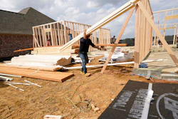 A workman carries beam at a new housing site in Madison County, Miss. on March 16.
