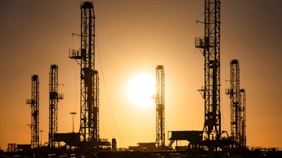 The morning sun rises behind oil rigs sitting in storage Saturday, Feb. 6 at a yard outside of Odessa, Texas.