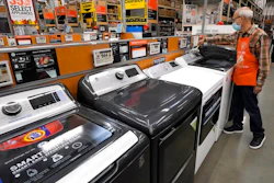 In this Oct. 29, 2020 photo, worker Javad Memarzadeh of Needham, MA dusts washers on a display at a Home Depot location in Boston.