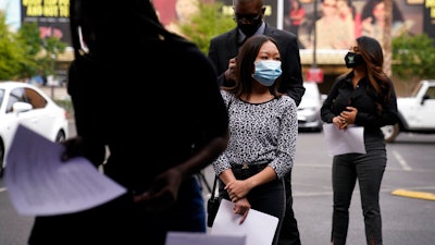 People wait in line, resumes in hand, while waiting to apply for jobs during an outdoor hiring event for the Circa resort and casino on April 27 in Las Vegas.