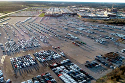 In this aerial photo, a General Motors assembly plant is seen at top right while mid-sized pickup trucks and full-size vans currently produced at the plant are seen in a parking lot outside on March 24 in Wentzville, Mo.
