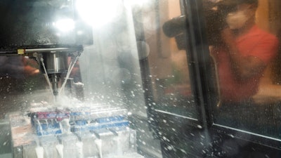 A videographer captures a CNC (computer numerical control) machine at work before a ribbon-cutting ceremony to mark the opening of a Nanotronics manufacturing center at the Brooklyn Navy Yard on April 28 in the Brooklyn borough of New York.