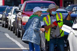 A customer helps pumping gas at Costco, as other wait in line, on Tuesday, May 11, 2021, in Charlotte, N.C. Colonial Pipeline, which delivers about 45% of the fuel consumed on the East Coast, halted operations last week after revealing a cyberattack that it said had affected some of its systems.