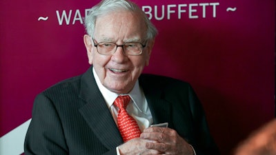 In this May 5, 2019, file photo Warren Buffett, Chairman and CEO of Berkshire Hathaway, smiles as he plays bridge following the annual Berkshire Hathaway shareholders meeting in Omaha, Neb. Buffett will spend Saturday afternoon fielding questions at Berkshire Hathaway's annual meeting, which is being held virtually.