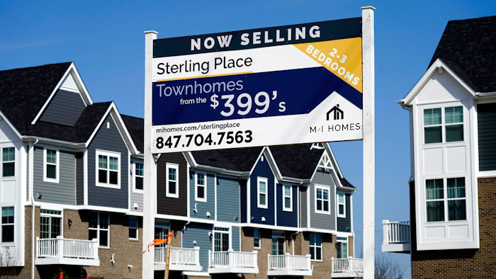 An advertising sign for building land stands in front of a new home construction site in Northbrook, IL on March 21.