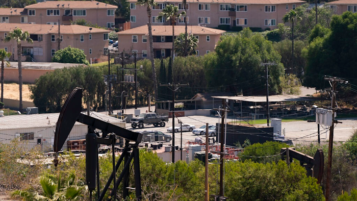 In this May 18, 2021, file photo, apartment buildings rise behind pump jacks operating at the Inglewood Oil Field in Los Angeles. California state oil regulators missed a spring deadline for new regulations designed to protect health and safety near oil and gas drillings sites. Environmental advocates have been pressuring Gov. Gavin Newsom's administration to adopt mandatory distances between wells and sites like schools and homes.