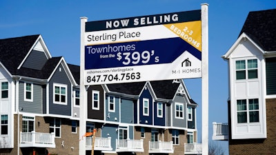 An advertising sign for building land stands in front of a new home construction site in Northbrook, IL on March 21.