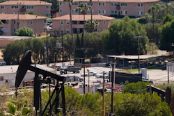 In this May 18, 2021, file photo, apartment buildings rise behind pump jacks operating at the Inglewood Oil Field in Los Angeles. California state oil regulators missed a spring deadline for new regulations designed to protect health and safety near oil and gas drillings sites. Environmental advocates have been pressuring Gov. Gavin Newsom's administration to adopt mandatory distances between wells and sites like schools and homes.