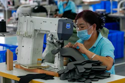 Workers wearing face masks to help curb the spread of the coronavirus sew layers for ice-skating shoes at a manufacturing factory in the ice and snow sports equipment industry park in Zhangjiakou in northwestern China's Hebei province on July 15.