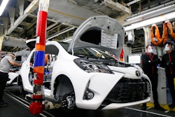 In this April 28, 2020 photo, an employee wearing a face mask works on a Yaris car at the Toyota car factory in Onnaing, northern France.