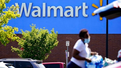 A shopper loads items into her car in the parking lot of a Walmart in Willow Grove, Pa., Wednesday, May 19, 2021. Walmart says it will start commercializing its delivery service, using contract workers, autonomous vehicles and even drones to deliver other retailers' products directly to their customers' homes as fast as just a few hours.