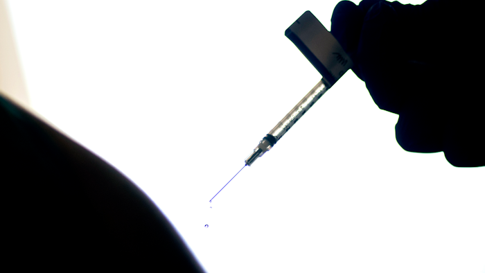 A droplet falls from a syringe after a person was injected with the Pfizer COVID-19 vaccine at a hospital in Providence, R.I., Dec. 15, 2020.