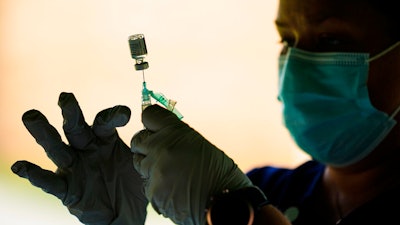 In this Sept. 14, 2021 photo, a syringe is prepared with the Pfizer COVID-19 vaccine at a clinic at the Reading Area Community College in Reading, Pa.