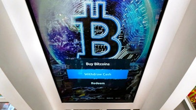 In this Feb. 9, 2021, file photo, the Bitcoin logo appears on the display screen of a cryptocurrency ATM at the Smoker's Choice store in Salem, N.H. China’s central bank on Friday, Sept. 24, 2021, declared all transactions involving Bitcoin and other virtual currencies illegal, stepping up a campaign to block use of unofficial digital money.