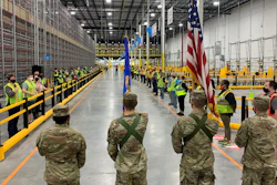 The North Dakota State University Color Guard leads associates through the Fargo Amazon Fulfillment Center's opening ceremony.