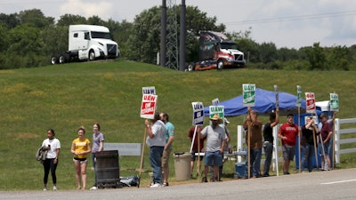 In this June 18, 2021 file photo, UAW Members strike outside the Volvo Trucks North America plant in Dublin, Va. With Help Wanted signs at factories and businesses spreading across the nation, in manufacturing and in service industries, union workers like those at the Volvo site are seizing the opportunity to try to recover some of the bargaining power — and financial security — they feel they lost in recent decades as unions shrank in size and influence.