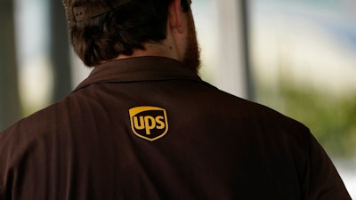 A UPS logo is on the shirt of a driver as he enters a United Parcel Service store with packages in Jackson, Miss., Monday, July 26, 2021. The Atlanta-based company said Thursday, Sept. 9, that it plans to hire more than 100,000 people for the busy holiday shipping season, many of whom will get job offers within 30-minutes of applying. UPS needs to snap up workers as fast as it can because of the tight job market.